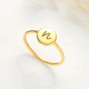 14k Gold filled ring with a circular emblem featuring a letter 'N' on a light background